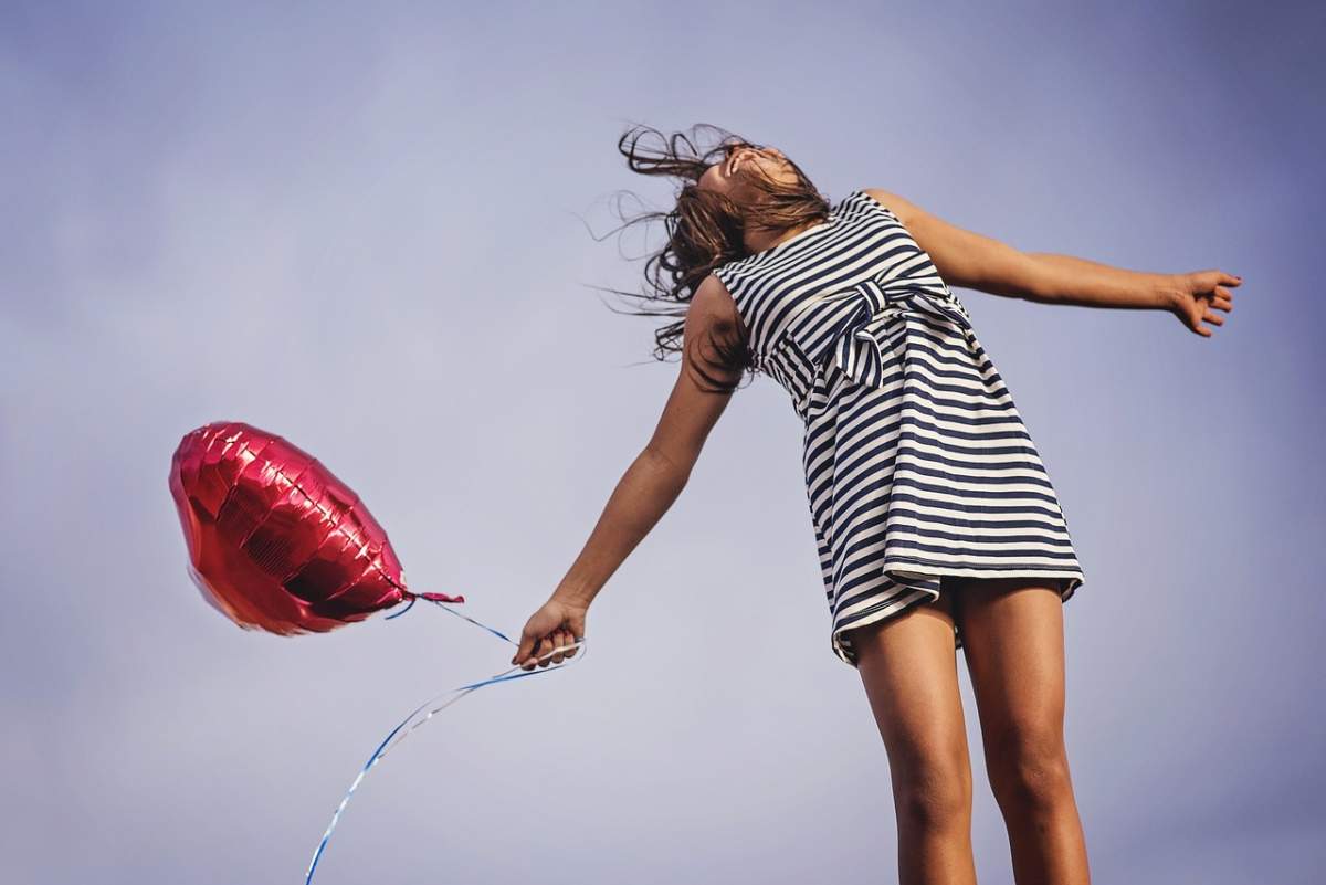 fata imbracata in rochie si cu balon in mana