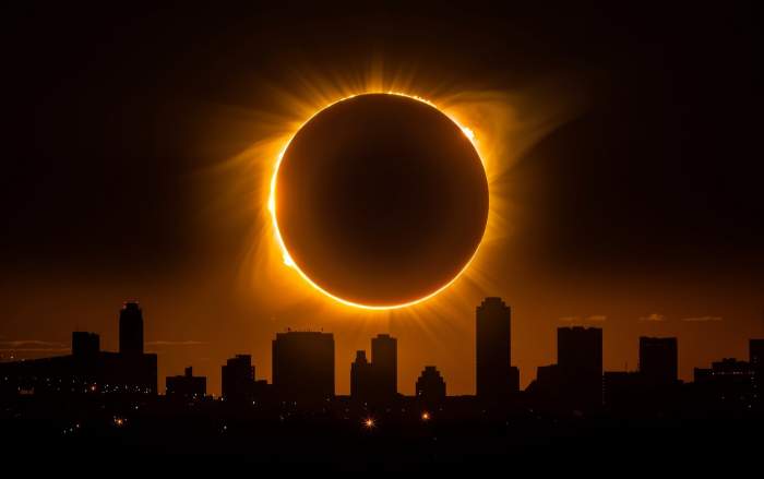eclipsă uluitoare pe un peisaj urban, cu strălucirea coroanei anunțând un spectacol cosmic