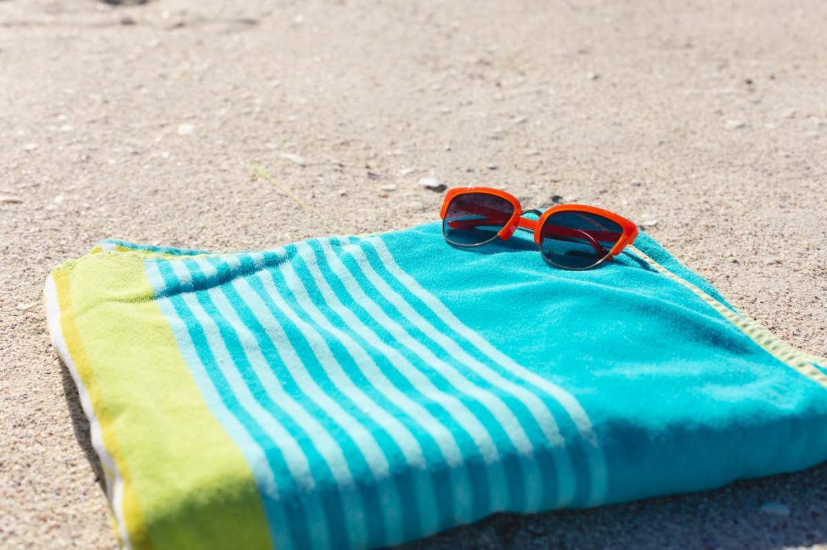 un prosop de plajă și o pereche de ochelari de soare