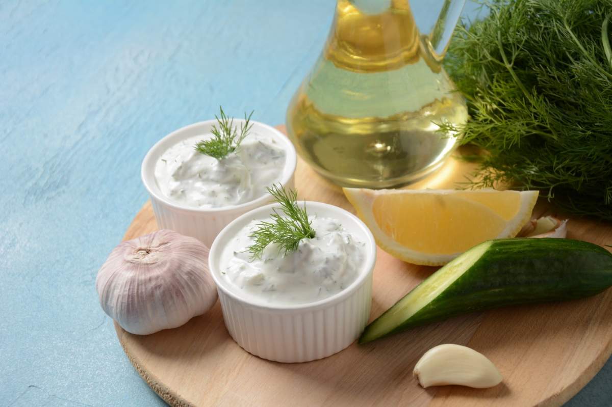 Sos tradițional grecesc pentru dip sau dressing tzatziki preparat cu castravete ras smântână iaurt ulei de măsline și mărar proaspăt.