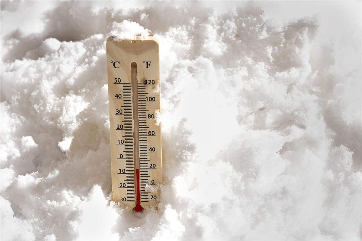Termometru în zăpadă care arată temperaturi sub zero grade într-o zi de iarnă