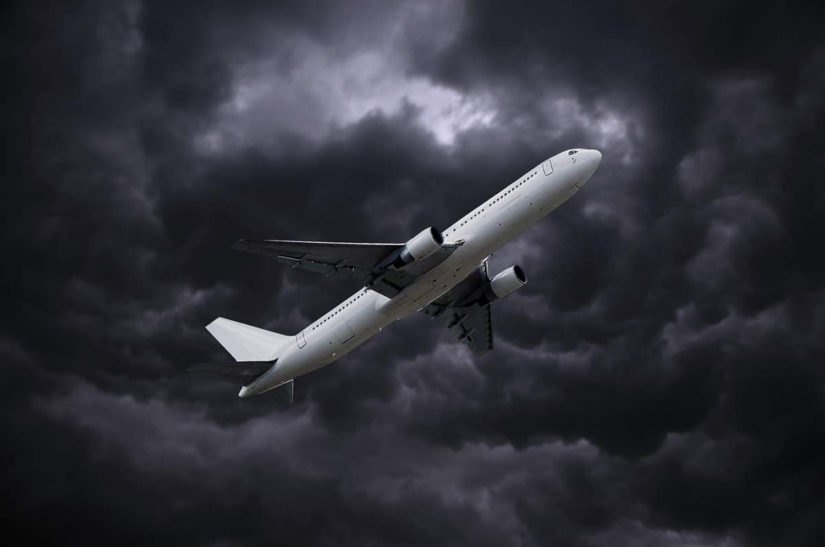 avion lipit pe fundal dramatic de cer înnorat și furtunos