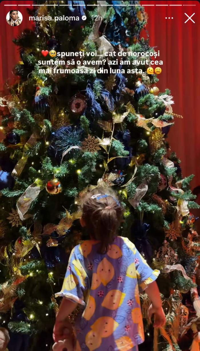 Fetița Marisei Paloma privește bradul de Crăciun