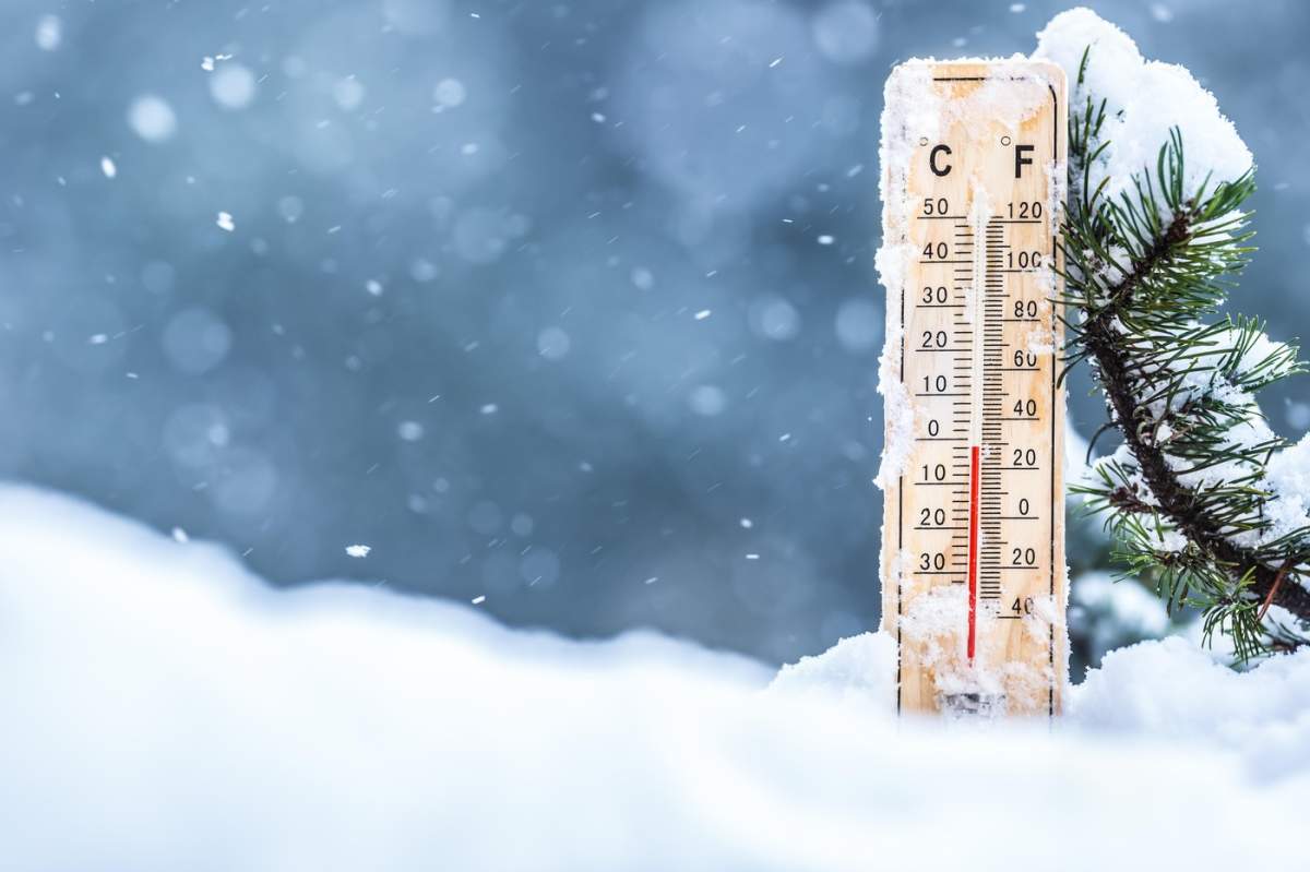Termometrul pe zăpadă arată temperaturi scăzute în grade Celsius sau Fahrenheit.