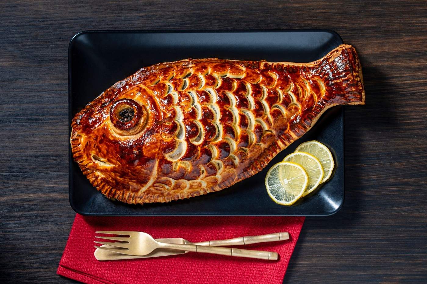 Pește dorado copt în aluat foietaj cu drojdie, prim-plan, vedere de sus. Concept de alimentație sănătoasă. Pește întreg învelit în aluat și copt la cuptor.