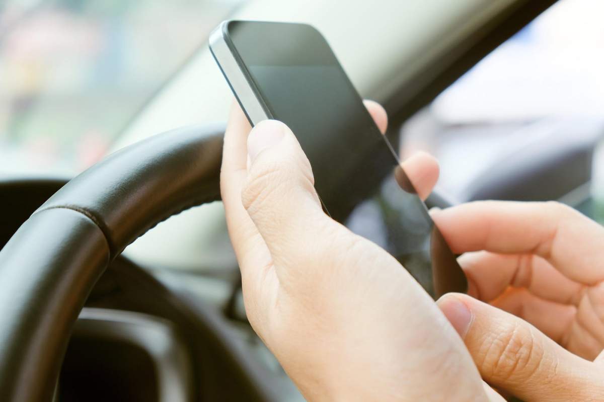 Un bărbat ține în mână un telefon mobil