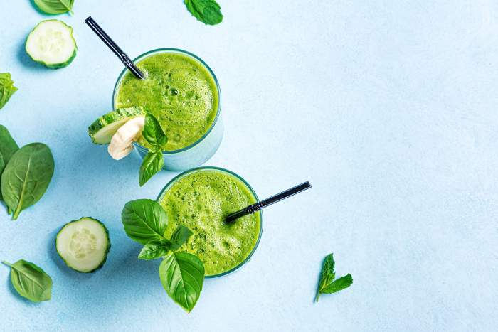 Detox smoothie verde în pahare pe fundal albastru deschis, vedere de sus, spațiu de copiere. Alimentație sănătoasă curată, concept de stil de viață vegan.