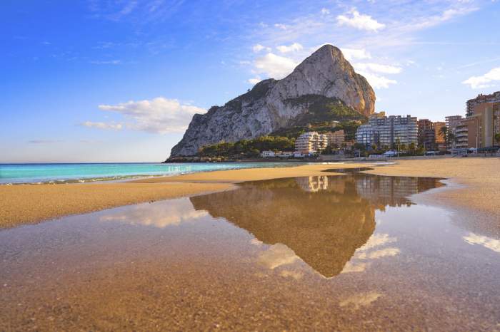 Plaja Playa de Fossa din Calpe și stânca Ifach Penon din Alicante în Spania