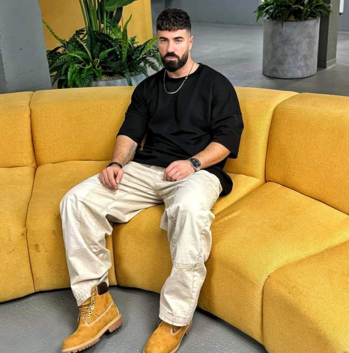 alex beni pe o canapea galbena