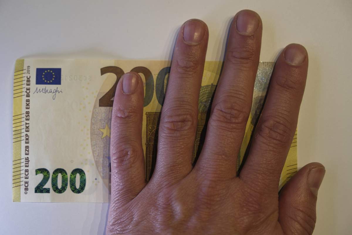 Imagine simbol pentru numerar, bancnotă de 200 de euro acoperită parțial de o mână, imagine macro, Renania de Nord-Westfalia, Germania, Europa