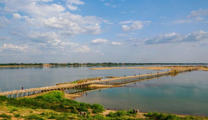 Călugării budiști trec pe podul de bambus dintre Kampong Cham și insula Kaoh Pan, Cambodgia