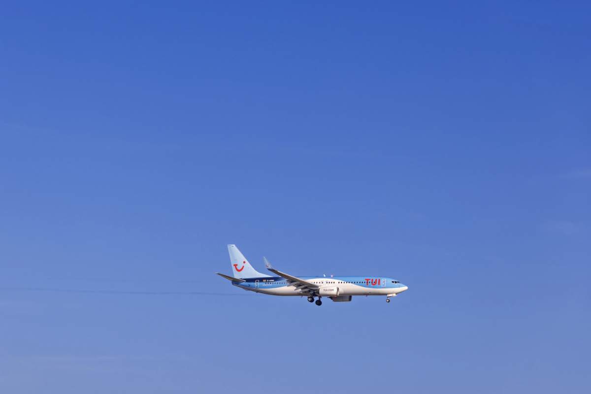 Avion de pasageri de la compania de turism Tui cu turiști care zboară pe un cer albastru, Mallorca, Spania, Europa