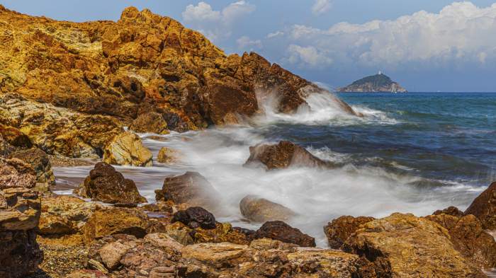 Stânci aspre și spumă pe plaja Topinetti, lângă Rio Marina, Insula Elba, Parcul Național Arhipelagul Toscanei, Toscana, Italia, Europa