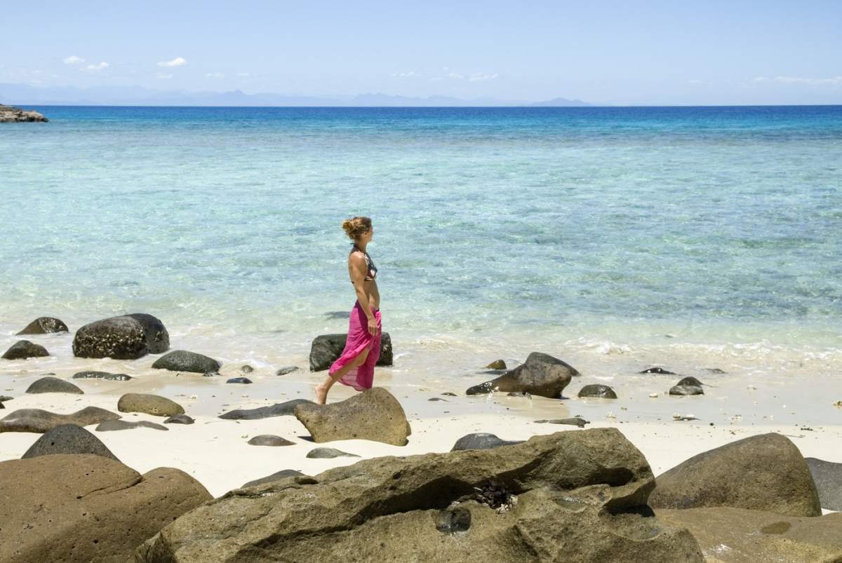 Tânără femeie mergând pe plajă, insula Tsarabanjina, arhipelagul Mitsio, Republica Madagascar, Oceanul Indian