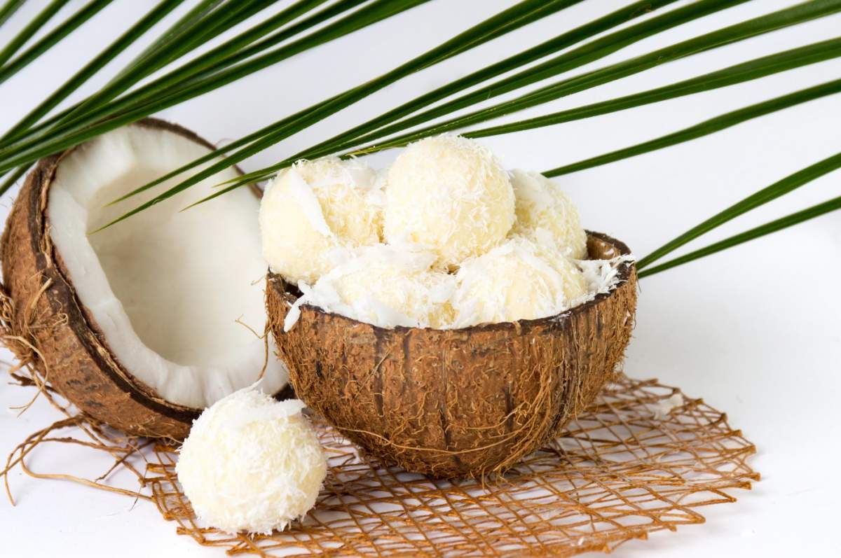 biluțe de nucă de cocos într-o coajă de cocos pe alb