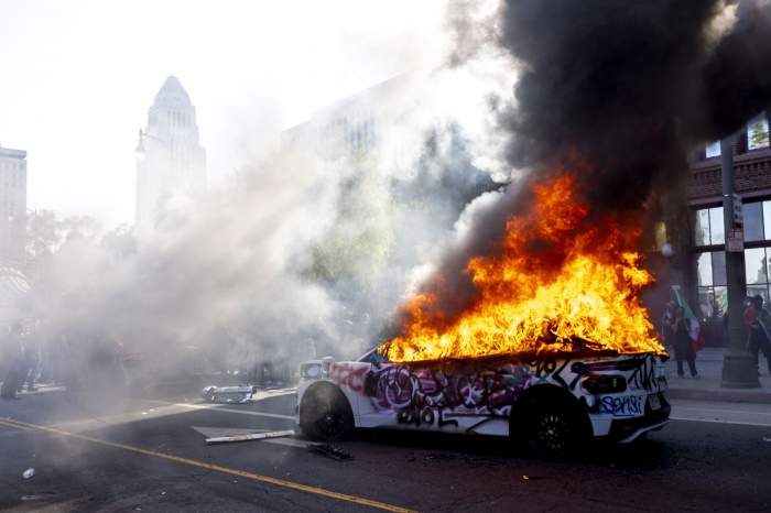 Una dintre mașinile Waymo care au fost incendiate în centrul Los Angeles-ului, unde sute de persoane s-au adunat pentru a protesta împotriva raziilor privind imigrația, pe 8 iunie 2025.
