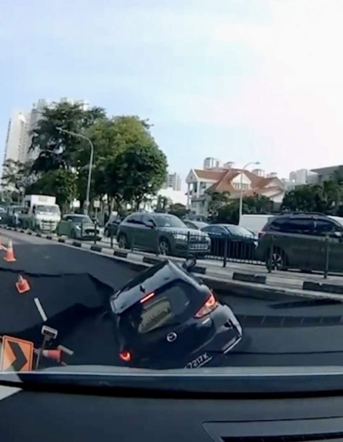 Mașină înghițită de o gaură uriașă în miezul zilei, pe șosea! Imaginile sunt șocante | VIDEO