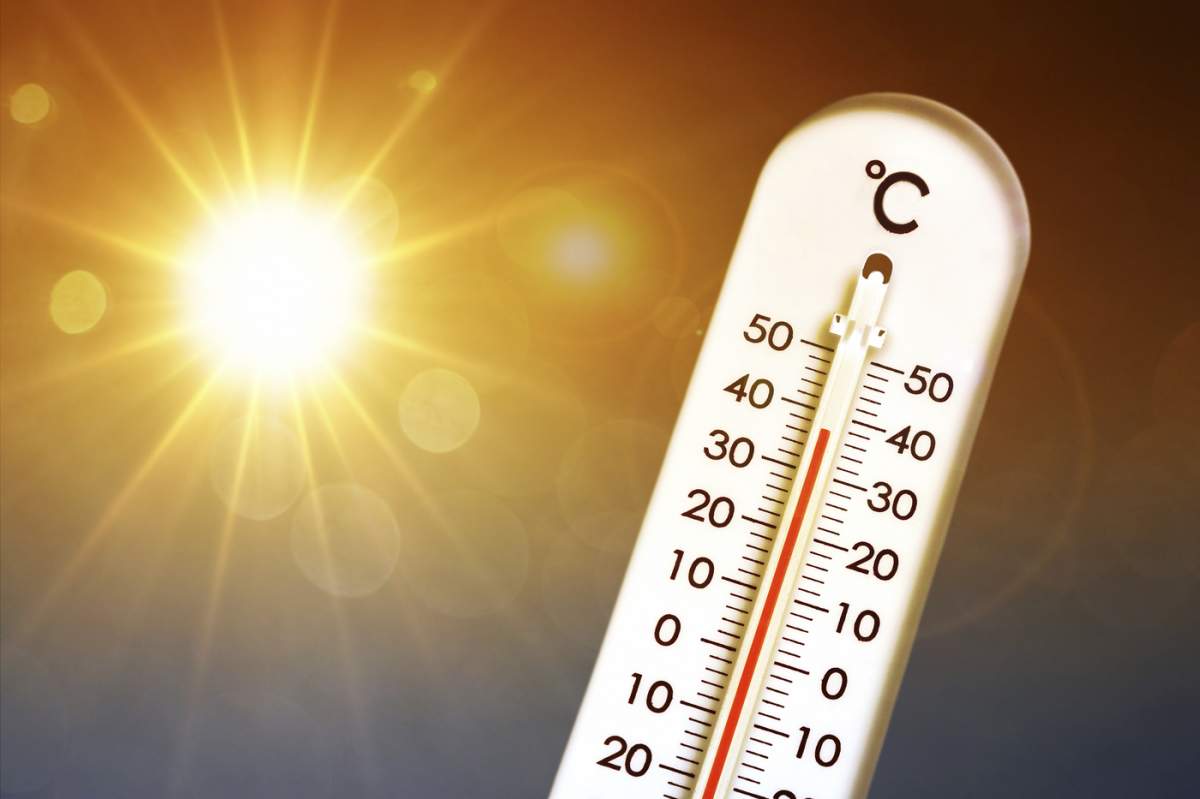 Termometru în fața soarelui arzător arată temperaturi ridicate, fotografie simbolică val de căldură, photomontage