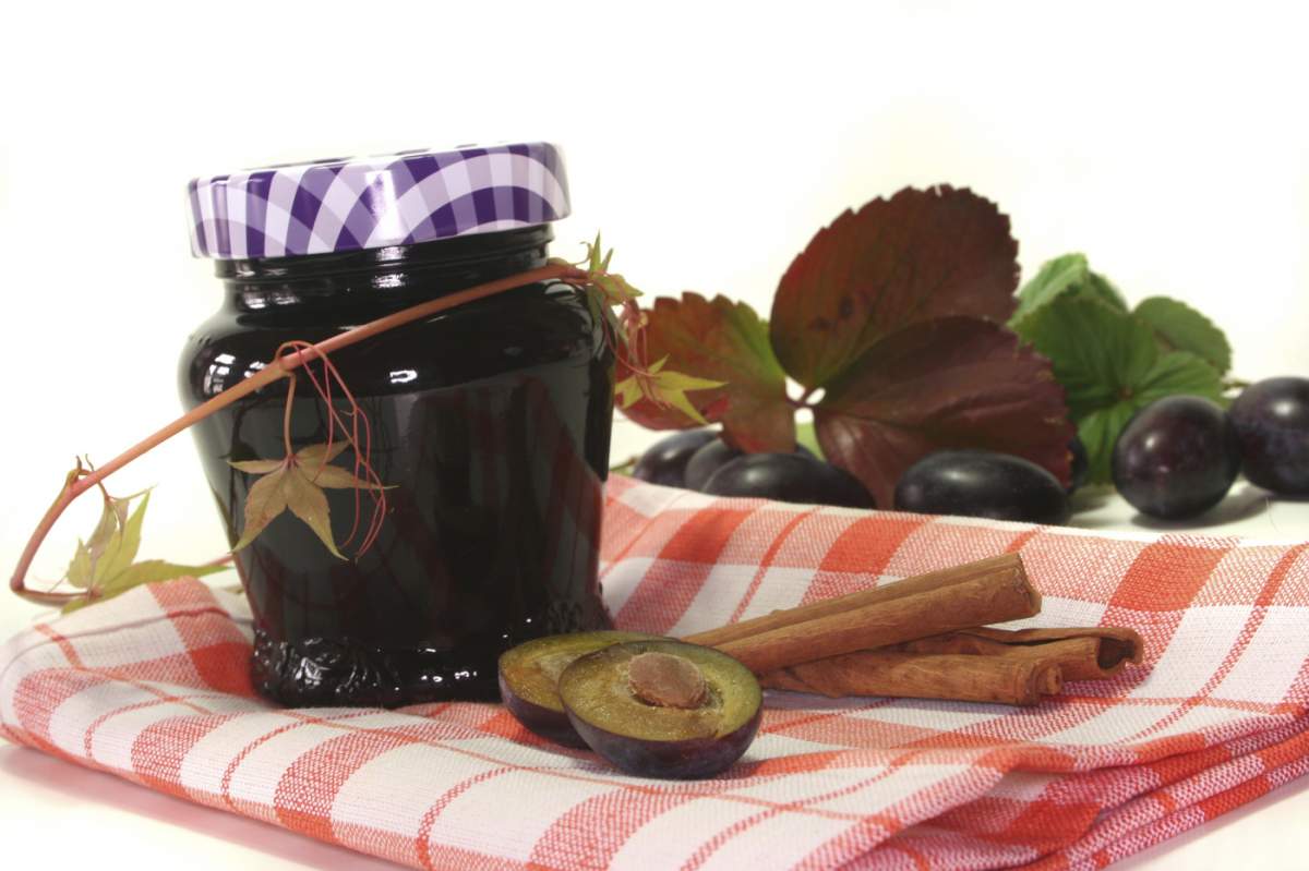 Un borcan de gem de prune cu ingrediente proaspete