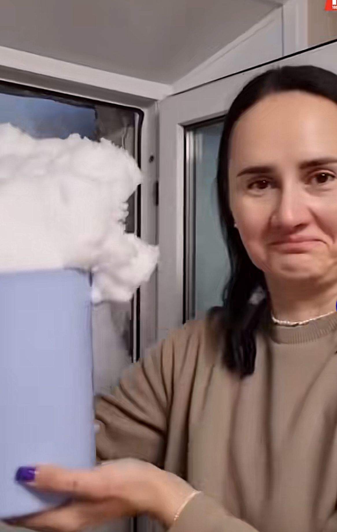 O femeie a scos zăpada de la geam cu găleata