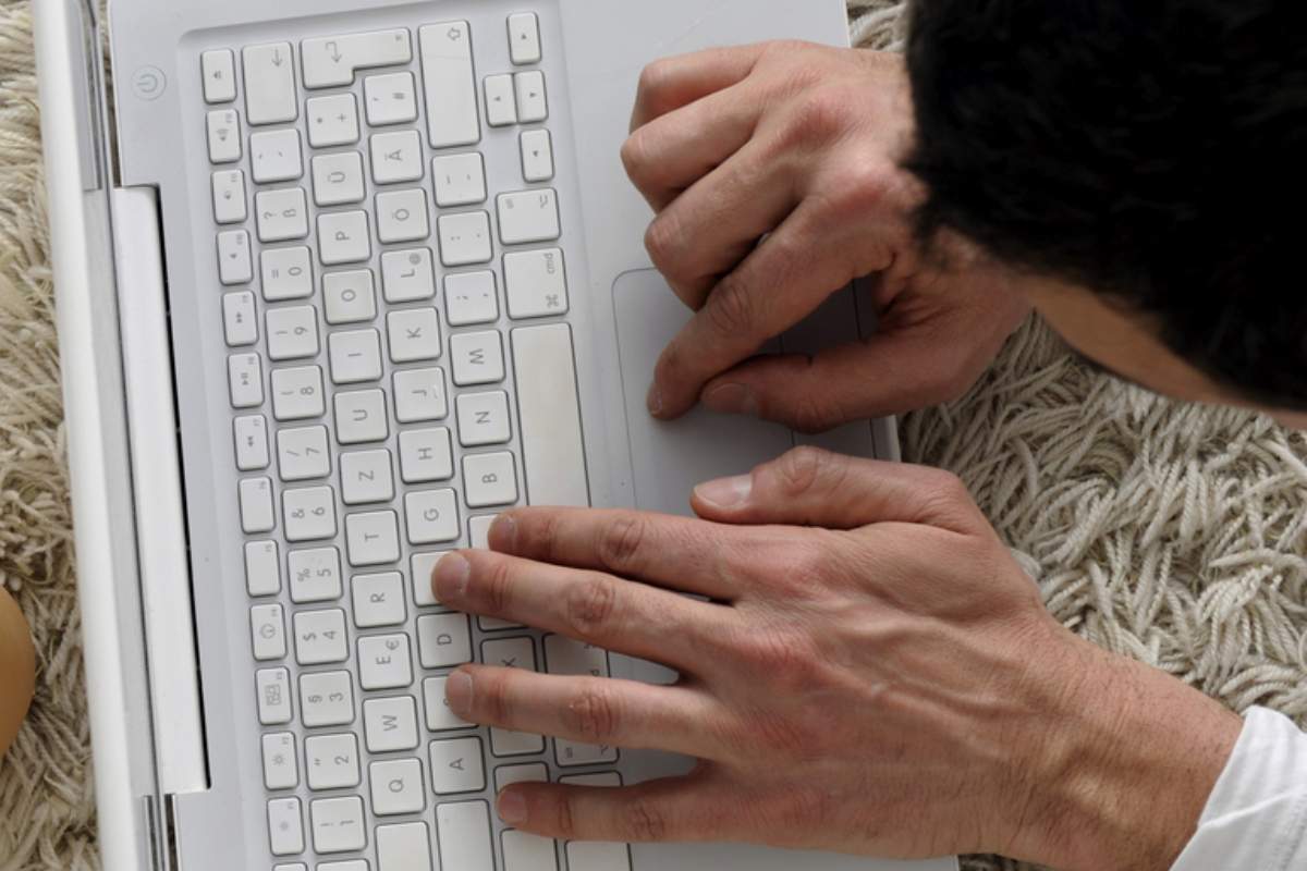 barbat care umbla pe laptop