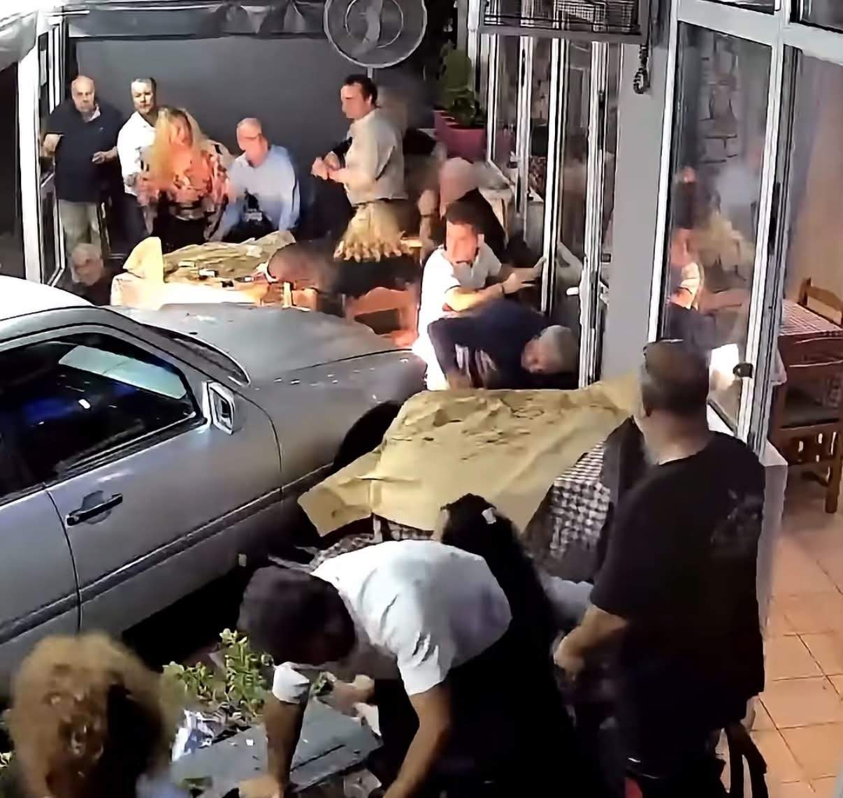 Momentul în care o mașină intră în plin într-o tavernă, printre clienți. Trei persoane au fost rănite