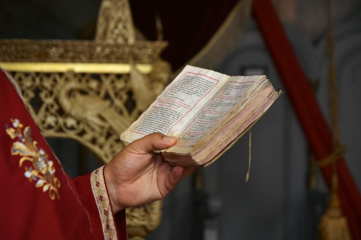 Preot citind din Biblie într-o biserică ortodoxă