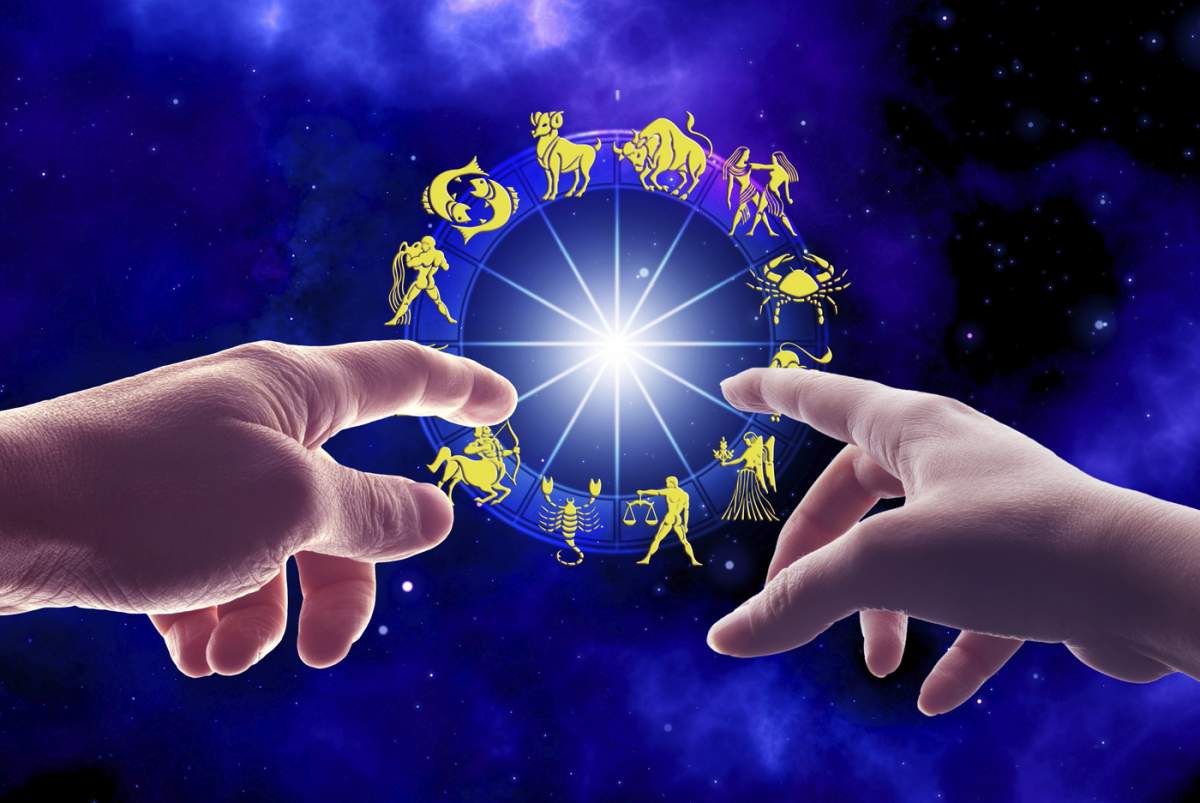 Două mâini întinse spre o stea strălucitoare centrală, înconjurată de simboluri zodiacale pe un fundal cosmic