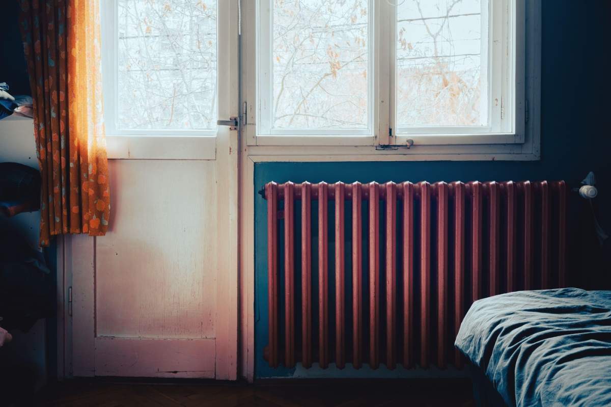Detalii despre vechiul calorifer roșu din camera de sub fereastră.