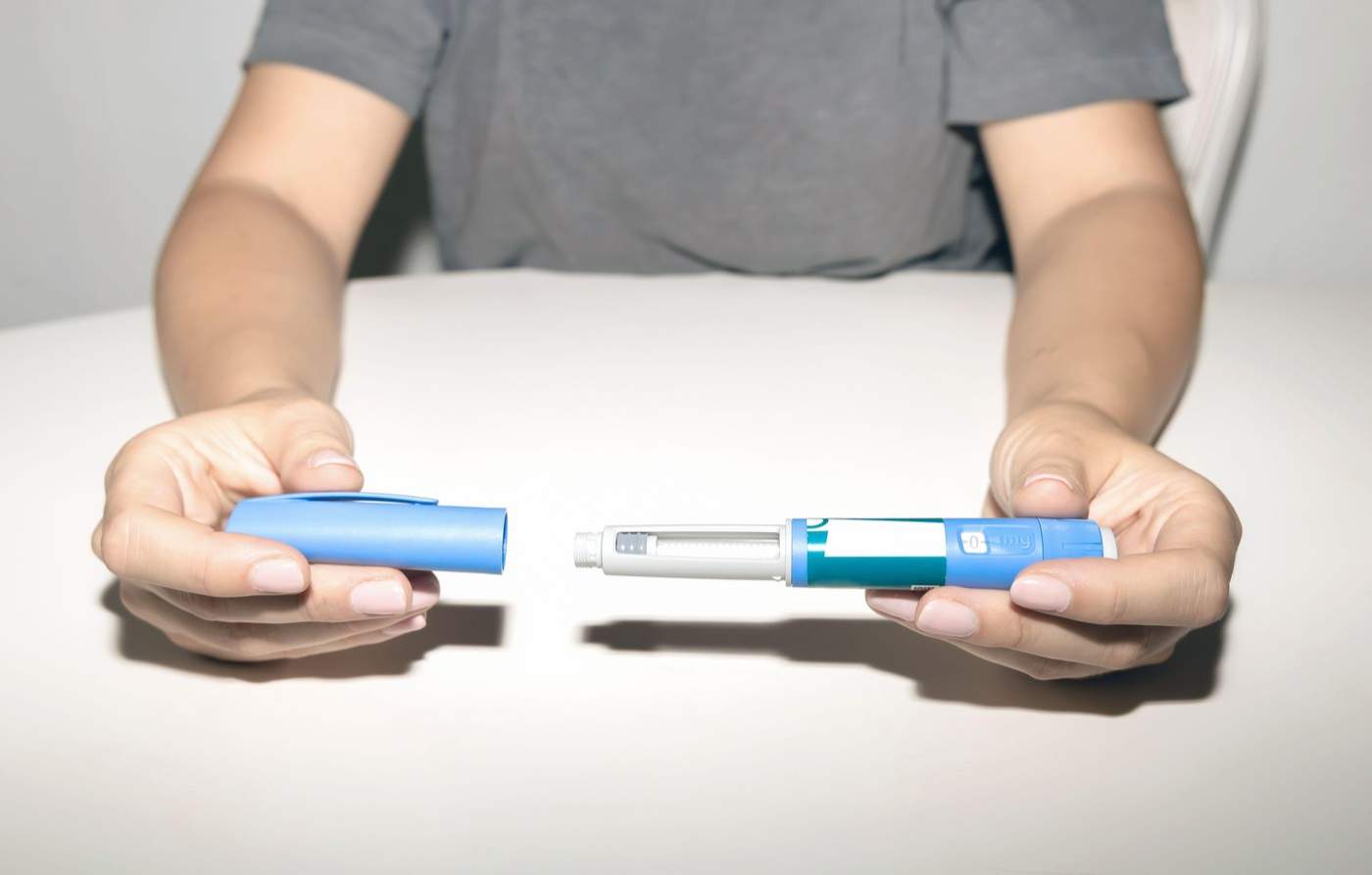 Mâini feminine ținând un stilou cu insulină. Stilou pentru injectarea insulinei Ozempic sau stilou cu cartuș de insulină pentru diabetici. Echipament medical pentru pacienții cu diabet.