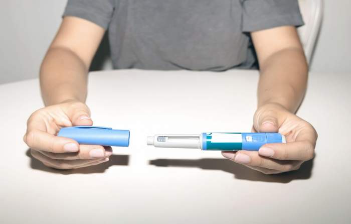 Mâini feminine ținând un stilou cu insulină. Stilou pentru injectarea insulinei Ozempic sau stilou cu cartuș de insulină pentru diabetici. Echipament medical pentru pacienții cu diabet.