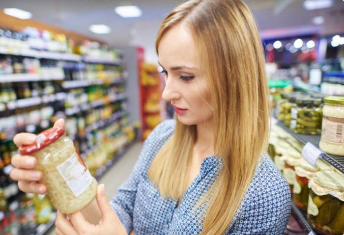 O femeie, verificând eticheta unui produs