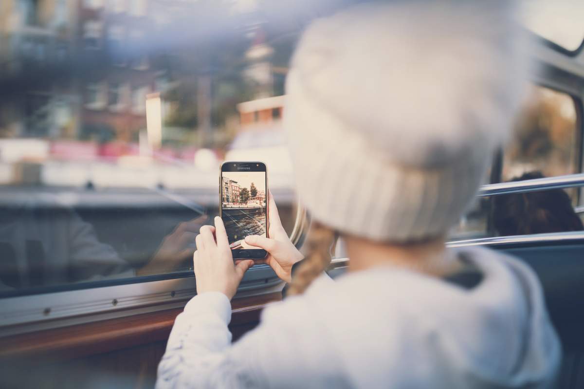 Tânără fată făcând poze cu smartphone-ul în Amsterdam