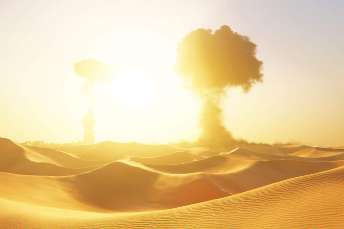 nori masivi în formă de ciupercă se ridică peste un vast deșert sub un soare arzător. Peisaj dramatic post-apocaliptic cu dune de nisip auriu și explozii nucleare.