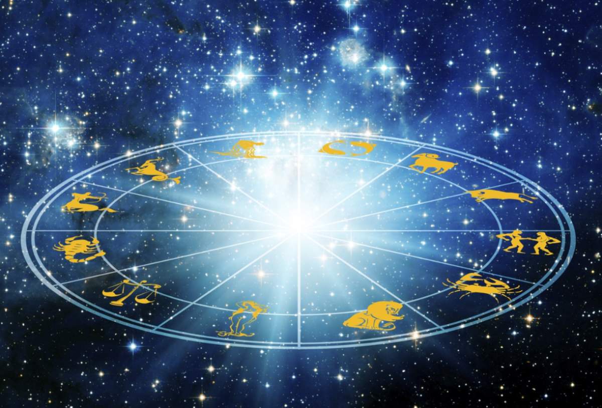 Roată astrologică cu semne zodiacale pe un fundal cosmic albastru înstelat