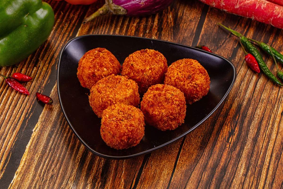 Vedere de sus a unor chifteluțe crocante, prăjite, cu legume