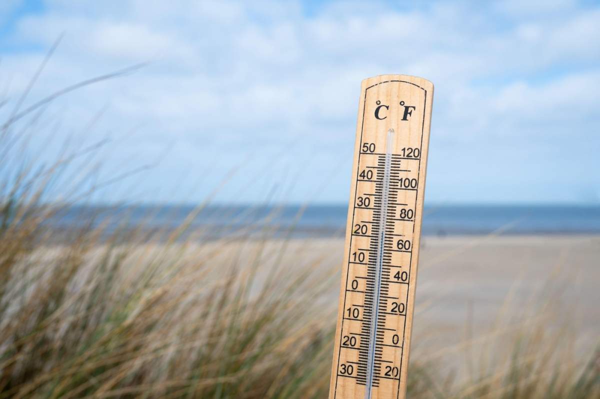 Termometru pe o plajă, cer albastru și soare, măsurătoare de temperatură ridicată, prognoză meteo, zi însorită, vacanță primăvară sau vară
