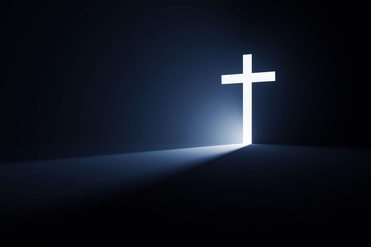 O cruce creștină strălucitoare într-o cameră întunecată. O lumină puternică strălucește printr-o deschizătură în formă de cruce din perete, aruncând o umbră lungă pe podea. Conceptul de