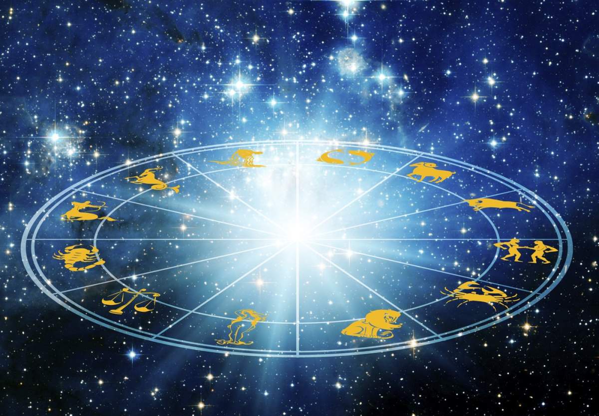 Roată astrologică cu semne zodiacale pe un fundal cosmic albastru înstelat
