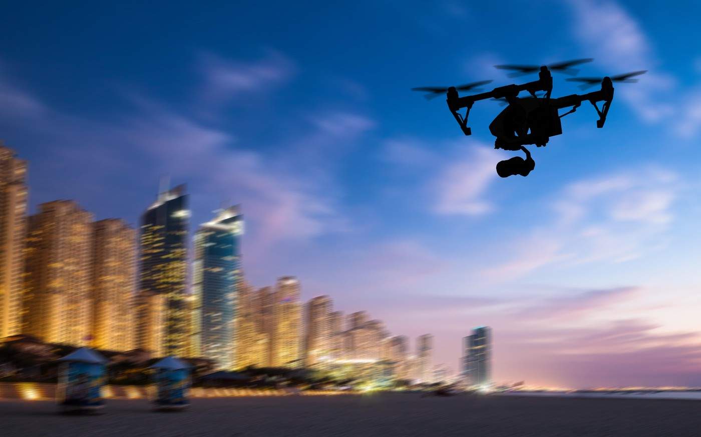 Siluetă de dronă zburând deasupra panoramei orașului Dubai