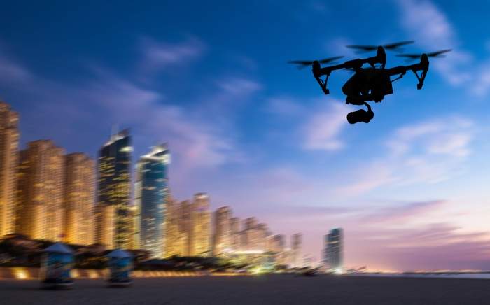 Siluetă de dronă zburând deasupra panoramei orașului Dubai