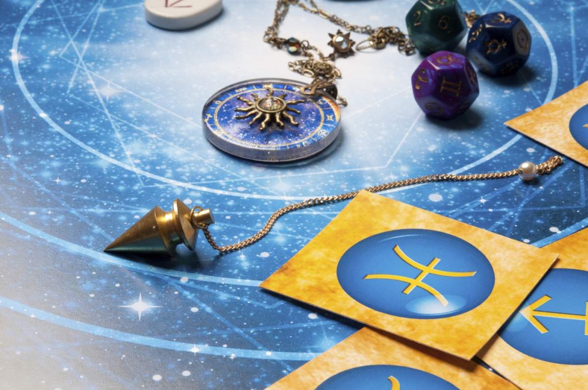 Configurație de divinație astrologică cu pendul, simboluri zodiacale și bijuterii pe un fundal cosmic