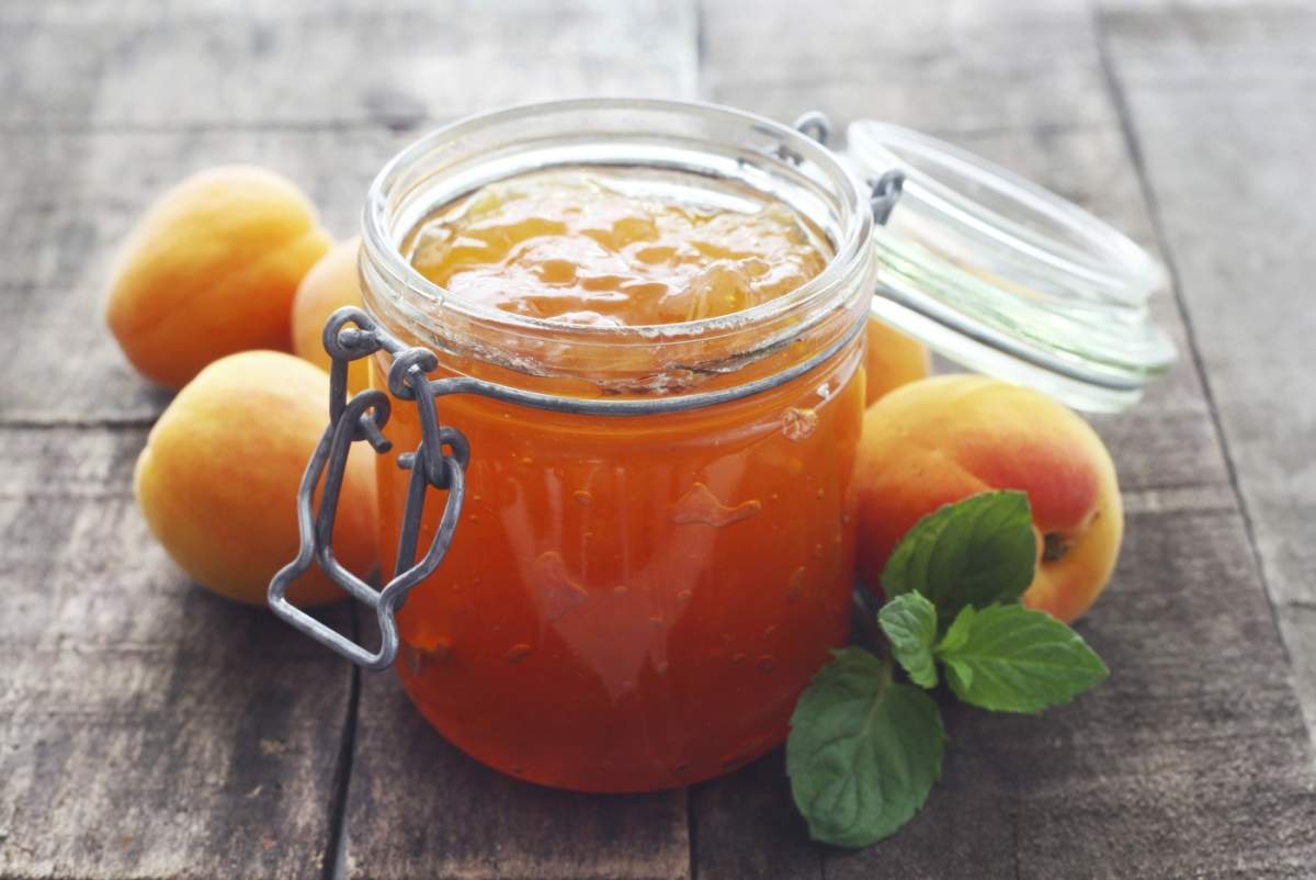 Mâncare, un borcan de dulceață de caise pe un fundal de lemn