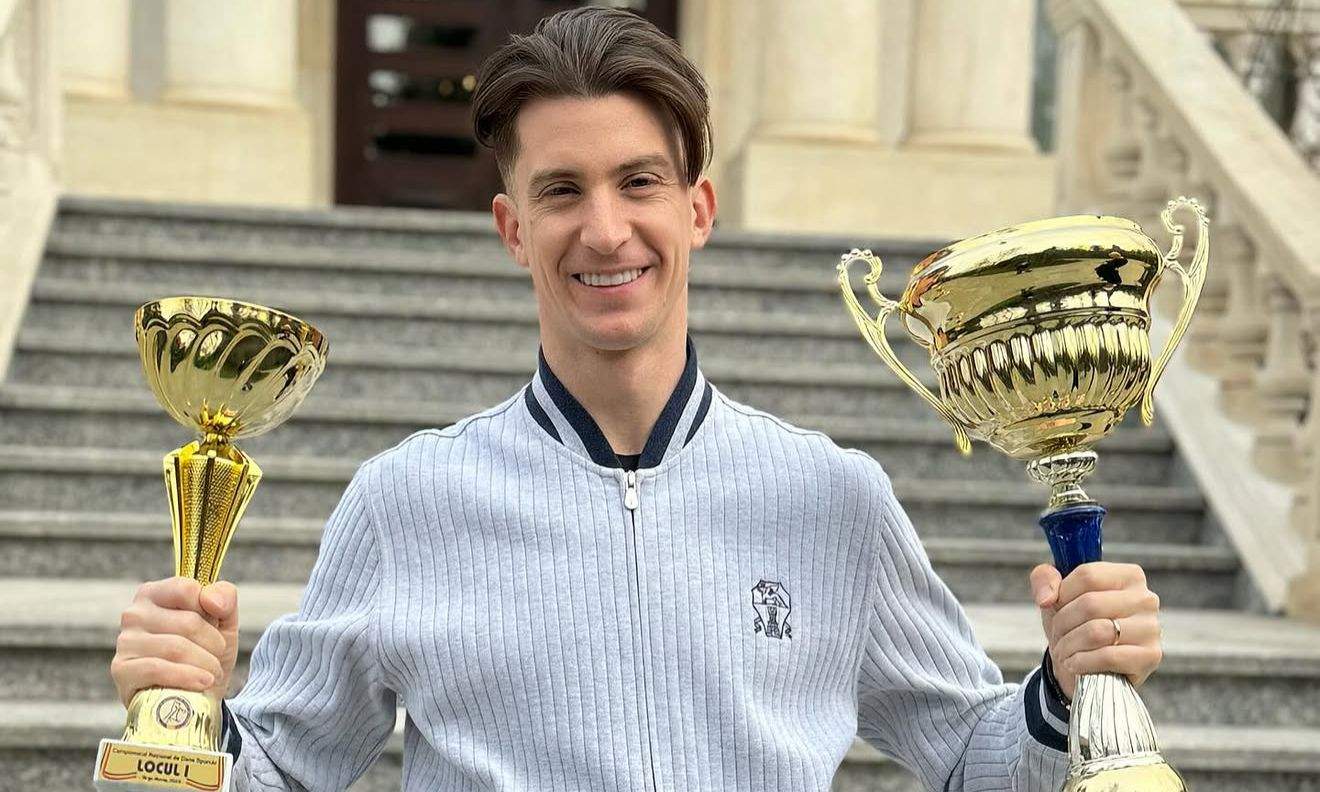 Rareș Cojoc ține în mână două trofee