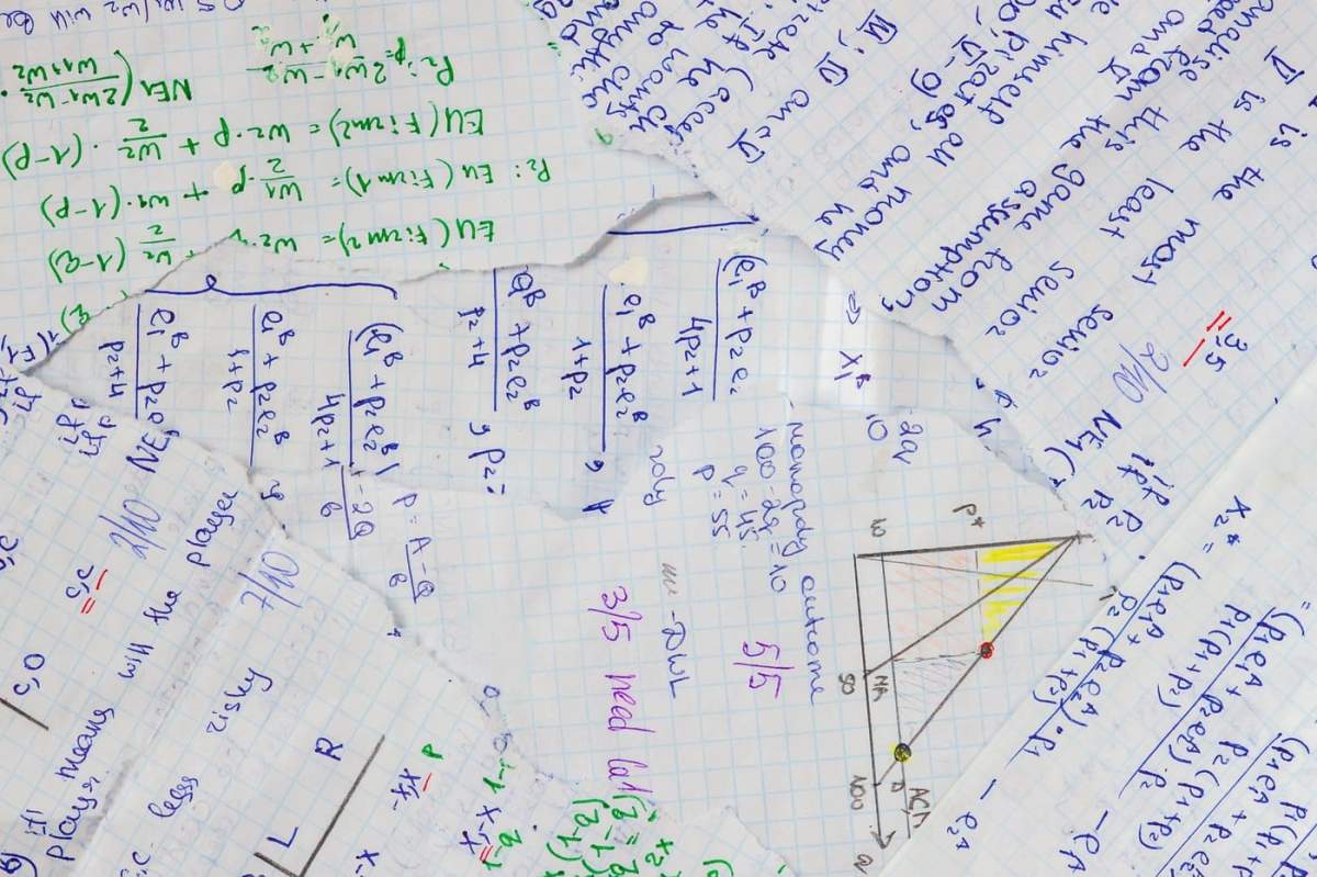 Colaj de bucăți de hârtie milimetrică albastră ruptă cu formule și notițe matematice scrise de mână