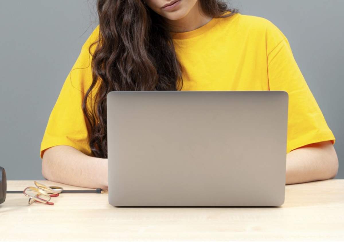 Tânără stând la masă, folosind tehnologia modernă atunci când lucrează, concept de lucru online