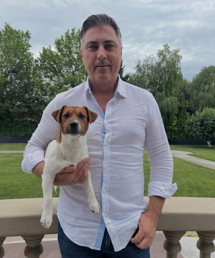 Alexandru Ciucu își ține în brațe cățelul