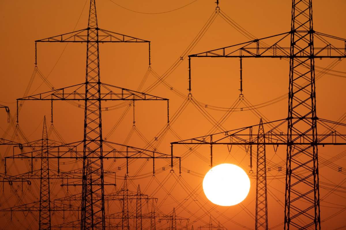 26 iunie 2026, Frankfurt, Hessa, Germania: Soarele răsare în spatele liniilor electrice în timpul unui val de căldură în Frankfurt pe Main, Germania.