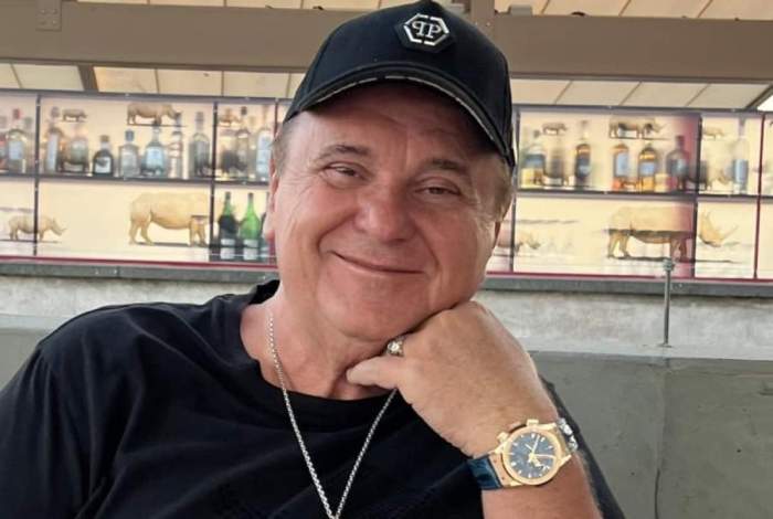 nick radoi cu un ceas la mana sta pe o canapea