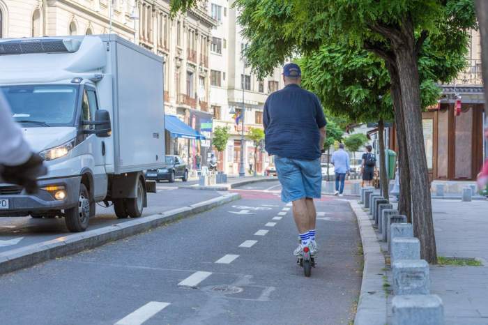 Un bărbat se plimbă cu trotineta
